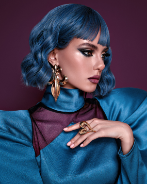 a beautiful wooman person with blue hair and gold earrings wow